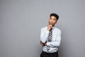 Business Concept - Confident thoughtful young African American holding hand on his chin and thinking about business. Royalty Free Stock Photo