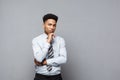 Business Concept - Confident thoughtful young African American holding hand on his chin and thinking about business. Royalty Free Stock Photo