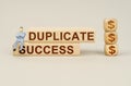 On the blocks with the inscription - Duplicate Success, the figure of a businessman sits, next to the cubes