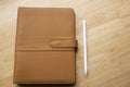 Top view of brown leather notebook with pen on wooden table Royalty Free Stock Photo