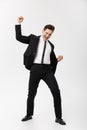 Business Concept: Full-length Portrait excited handsome business man with arms raised in success. Isolated on grey Royalty Free Stock Photo