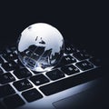 Business concept of glass globe on a laptop keyboard Royalty Free Stock Photo