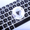 business concept of glass globe on a laptop keyboard Royalty Free Stock Photo