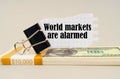 There are dollars on the table, on which there is a clip and torn paper with the inscription - World markets are alarmed Royalty Free Stock Photo
