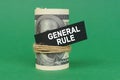 On a green surface, rolled dollars with a black sign that says - GENERAL RULE