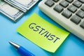 Business concept about GST/HST Goods Services Tax Harmonized Sales Tax with inscription on the sheet