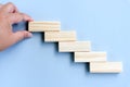 Hand arranging wood block stacking as step stair Royalty Free Stock Photo