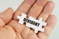 In the hand of a man are puzzles with the inscription - Divident Royalty Free Stock Photo