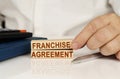 In the hands of a businessman, wooden blocks with the inscription - franchise agreement Royalty Free Stock Photo