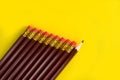Business concept - lot of same pencils and one different pencil on yellow paper background. It`s symbol of leadership, teamwork. Royalty Free Stock Photo