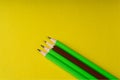 Business concept - lot of same pencils and one different pencil on yellow paper background. It`s symbol of leadership, teamwork. Royalty Free Stock Photo