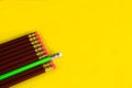 Business concept - lot of same pencils and one different pencil on yellow paper background. It`s symbol of leadership, teamwork. Royalty Free Stock Photo