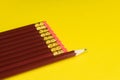 Business concept - lot of same pencils and one different pencil on yellow paper background. It`s symbol of leadership, teamwork. Royalty Free Stock Photo