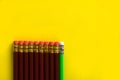 Business concept - lot of same pencils and one different pencil on yellow paper background. It`s symbol of leadership, teamwork. Royalty Free Stock Photo