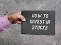 Business concept meaning HOW TO INVEST IN STOCKS with phrase on the page