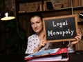 Business concept meaning Legal Monopoly with phrase on black chalkboard in hand Royalty Free Stock Photo