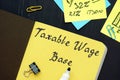 Business concept meaning Taxable Wage Base with sign on the sheet