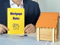 Business concept about Mortgage Rates with sign on yellow notepad in hand Royalty Free Stock Photo