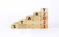 Business concept of 2021 new year start. Wooden blocks with words `Start 2021`. Beautiful white background, copy space. 2021 new