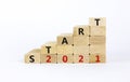 Business concept of 2021 new year start. Wooden blocks with words `Start 2021`. Beautiful white background, copy space. 2021 new