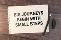 Business concept. Notebook with text Big journeys begin with small steps sheet. Royalty Free Stock Photo