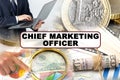 A businessman holds a folder with documents, the text on the folder is - CHIEF MARKETING OFFICER