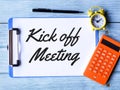 Phrase kick off meeting written on paper clipboard