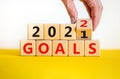 Business concept of planning 2022 goals symbol. Businesman turns a wooden cube and changes words `Goals 2021` to `Goals 2022`.