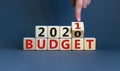 Business concept of planning 2021. Male hand flips wooden cube and change the inscription `BUDGET 2020` to `BUDGET 2021`. Royalty Free Stock Photo