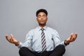 Business Concept - portrait of african american businessman doing meditation and yoga in before working. Royalty Free Stock Photo