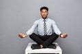 Business Concept - portrait of african american businessman doing meditation and yoga in before working. Royalty Free Stock Photo