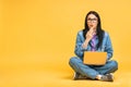 Business concept. Portrait of amazed shocked surprised young woman in casual sitting on floor in lotus pose and holding laptop Royalty Free Stock Photo