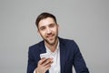 Business Concept - Portrait handsome happy handsome business man in suit playing moblie phone and smiling with laptop at work offi