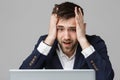 Business Concept - Portrait handsome stressful business man in suit shock looking at work in laptop. White Background.