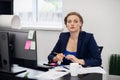 Business concept. A portrait of a young attractive business woman sitting at her desk looking at the camera Royalty Free Stock Photo