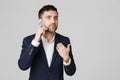 Business Concept - Portrait young handsome angry business man in suit talking on phone looking at camera. White background. Royalty Free Stock Photo