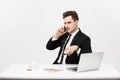 Business Concept: Portrait young successful businessman working in bright office, using laptop, talking on phone. Royalty Free Stock Photo