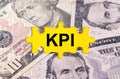 Puzzle with the image of dollars in the center of the inscription -KPI Royalty Free Stock Photo