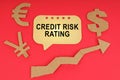 On the red surface there are money symbols, an arrow and a sign with the inscription - Credit risk rating