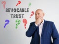 Business concept about REVOCABLE TRUST question marks with sign on the gray wall