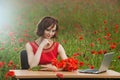 Business concept shot of a beautiful young woman sitting at a desk using a computer in a field. Royalty Free Stock Photo