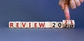 Business concept of starting 2021. Yand flips wooden cubes and changes the words `Review 2020` to `Review 2021`. Beautiful gre