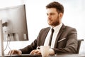 Business concept. Successful young businessman at work. Manager sitting at the office table and working on computer Royalty Free Stock Photo