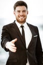 Business concept. Successful young businessman at work. Manager standing in office happy reaches out for a handshake Royalty Free Stock Photo