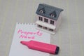 Business concept. On a surface is a model house, a pen and a notepad with an inscription - Property News.