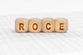On the table with documents are wooden cubes with the inscription - ROCE Royalty Free Stock Photo