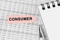 On the table among the reports is a notebook, a pen with an arrow with the inscription - CONSUMER Royalty Free Stock Photo