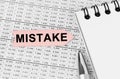 On the table among the reports is a notebook, a pen with an arrow with the inscription - MISTAKE Royalty Free Stock Photo