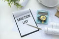 Business concept.Text SANCTIONS LIST with pen,glasses and magnifying glass on white background