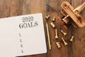 Business concept of top view 2020 goals list with notebook, chess figures and old plane toy over wooden desk Royalty Free Stock Photo